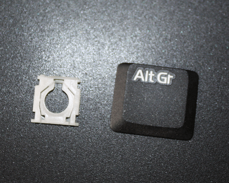 The two white bits, reunited, waiting to be set back into place underneath the key plate.